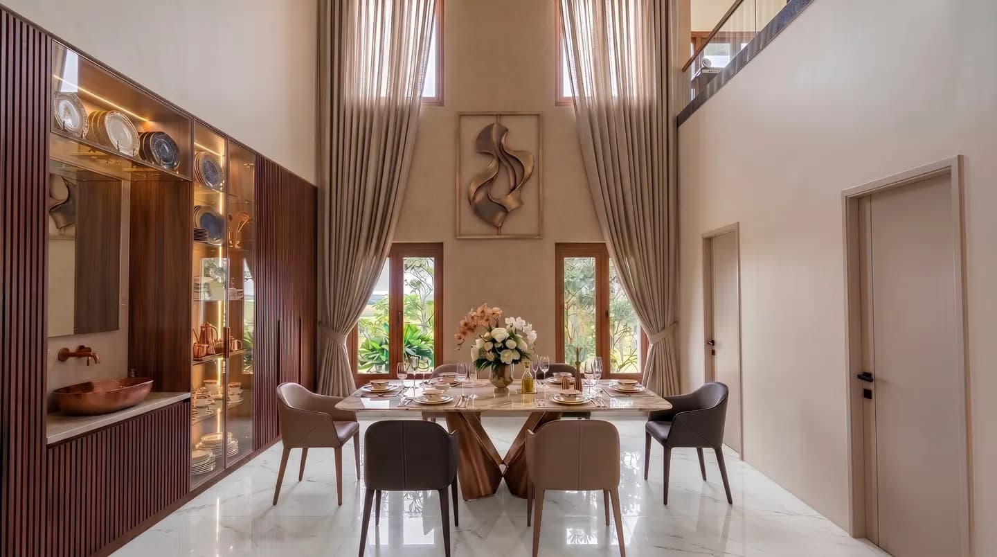 Double-height dining space with tall windows and warm material finishes