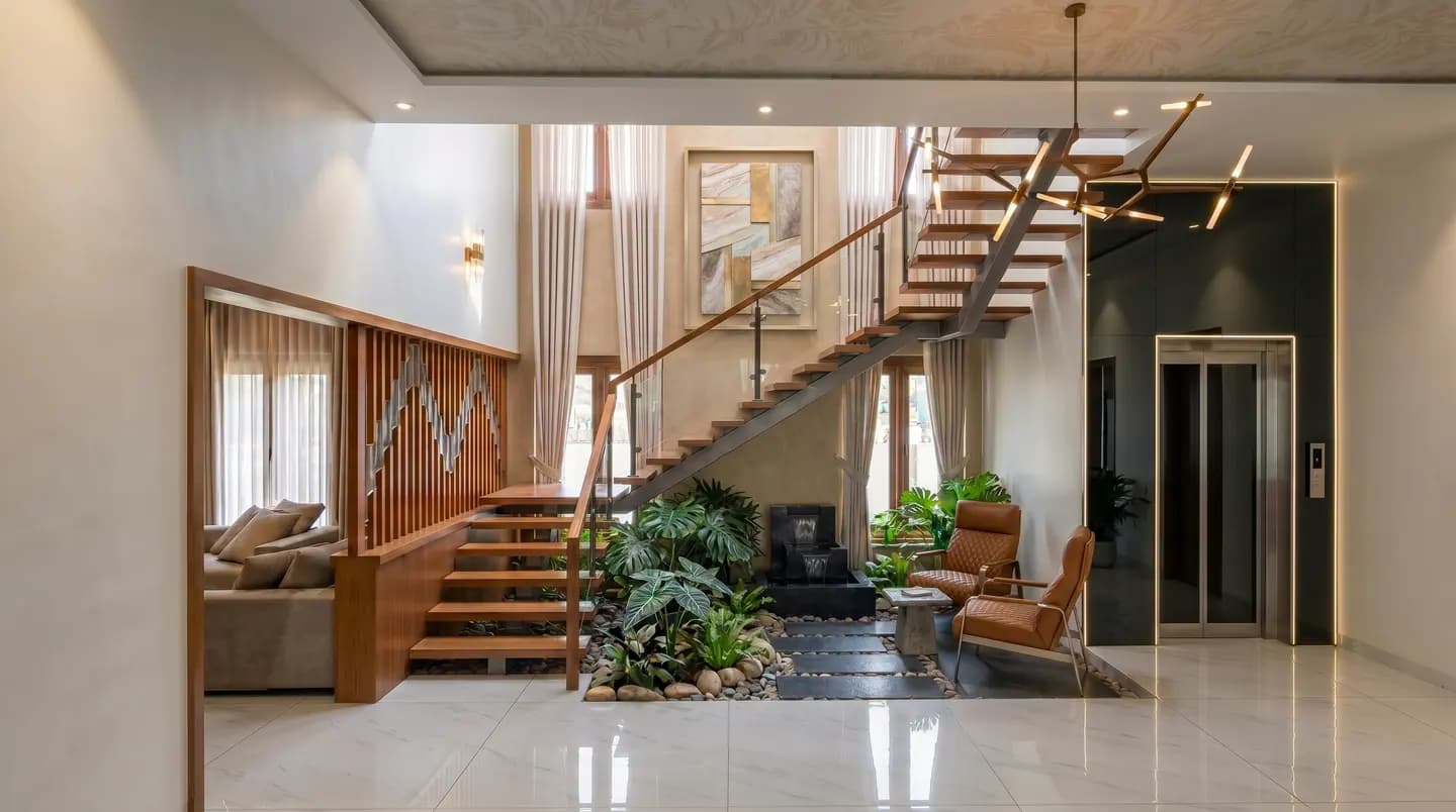 Double-height interior with an open timber staircase, planted courtyard and warm natural light